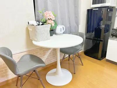 a white table with two chairs and a table with flowers at \u6c60\u888b\u96fb\u8eca2\u5206\u6700\u59274\u4eba 302 in Tokyo