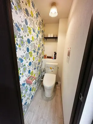 a bathroom with a toilet with a floral wallpaper at \u4e09\u30ce\u8f2a201 in Tokyo