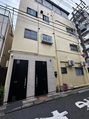 a building with black doors on the side of a street at \u4e09\u30ce\u8f2a201 in Tokyo