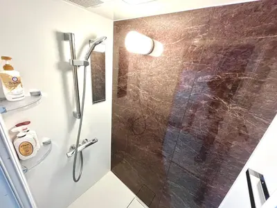 a bathroom with a shower with a glass door at \u30bf\u30b9\u30adsmart\u795e\u697d\u5742II in Tokyo