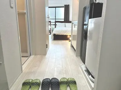 a row of pairs of shoes in a hallway with a refrigerator at \u30bf\u30b9\u30adsmart\u795e\u697d\u5742II in Tokyo