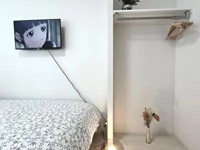 a bedroom with a bed and a tv on the wall at \u30bf\u30b9\u30adsmart\u795e\u697d\u5742II in Tokyo