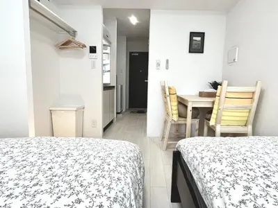 a bedroom with two beds and a table and chairs at \u30bf\u30b9\u30adsmart\u795e\u697d\u5742II in Tokyo