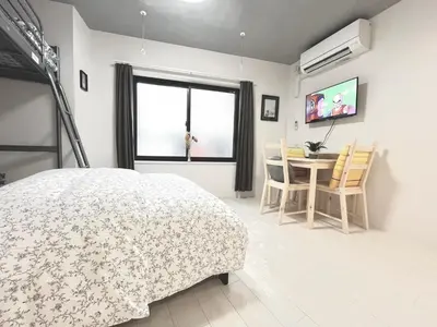 a bedroom with a bed and a table with chairs at \u30bf\u30b9\u30adsmart\u795e\u697d\u5742II in Tokyo
