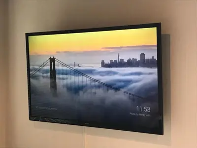a flat screen tv hanging on a wall with a city at EstLargo Meguro in Tokyo