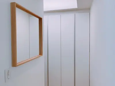 a window with a wooden frame on a white wall at EstLargo Meguro in Tokyo
