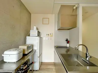 a small kitchen with a sink and a refrigerator at EstLargo Meguro in Tokyo