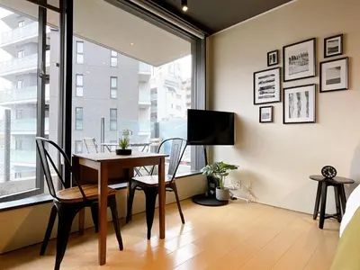 a dining room with a table and chairs and a window at EstLargo Meguro in Tokyo