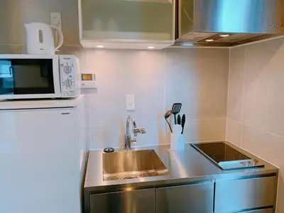 a small kitchen with a sink and a microwave at EstLargo Meguro in Tokyo