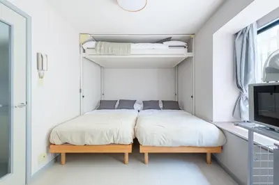 two beds in a small room with a tv at \u30e1\u30be\u30f3\u30c9\u30df\u30ca101\u53f7\u5ba4 in Tokyo
