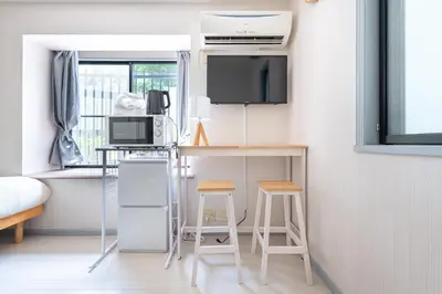 a small room with a desk and a tv and stool at \u30e1\u30be\u30f3\u30c9\u30df\u30ca101\u53f7\u5ba4 in Tokyo