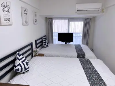 a bedroom with two beds and a flat screen tv at \u65b0\u5bbf\u6700\u4e2d\u5fc3 \u6b4c\u821e\u4f0e\u753a \u4e1c\u65b0\u5bbf4\u5206\u949f \u65b0\u5bbf10\u5206\u949f \u76f4\u8fbe\u6da9\u8c37\u539f\u5bbf \u65b0\u5bbf\u5fa1\u82d1\u5f92\u6b658\u5206\u949f in Tokyo