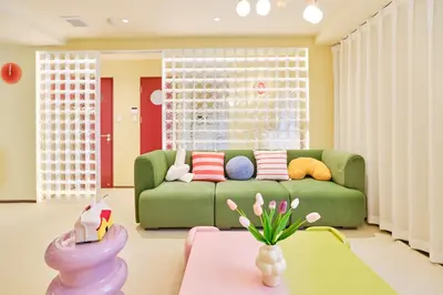 a living room with a green couch and a table at \u5bc5\u30db\u30c6\u30eb \u5fa1\u5f92\u753a TORA HOTEL Okachimachi in Tokyo