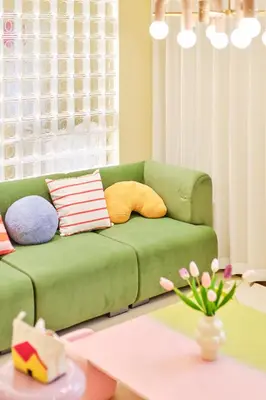 a green couch with pillows in a living room at \u5bc5\u30db\u30c6\u30eb \u5fa1\u5f92\u753a TORA HOTEL Okachimachi in Tokyo
