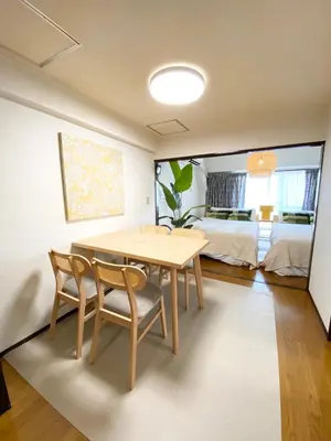a dining room with a table and two chairs and a bedroom at \u6075\u6bd4\u5bff\u99c5\u304b\u3089\u5f92\u6b691\u5206 \u6e0b\u8c373\u5206 \u65b0\u5bbf10\u5206 30m2\u3067\u3086\u3063\u305f\u308a \u6700\u9ad8\u306e\u7acb\u5730 303\u53f7\u5ba4 in Tokyo