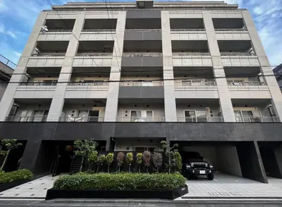 an apartment building with a car parked in front of it at Dash Living Ryogoku in Tokyo