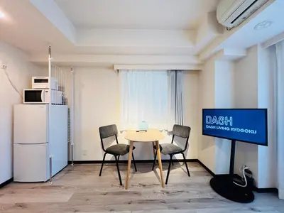 a dining room with a table and chairs and a tv at Dash Living Ryogoku in Tokyo