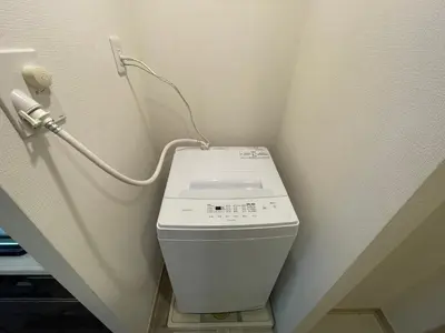 a washing machine in a corner of a room at Dash Living Ryogoku in Tokyo
