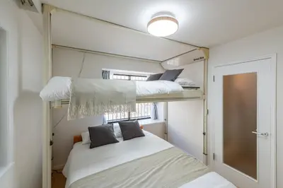 a bedroom with two bunk beds and a window at \u30e1\u30be\u30f3\u30c9\u30df\u30ca102\u53f7\u5ba4 in Tokyo