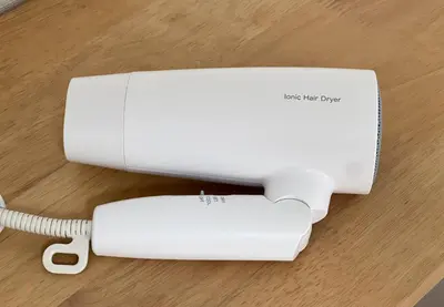 a white nintendo wii game system with a charger at \u30e1\u30be\u30f3\u30c9\u30df\u30ca103\u53f7\u5ba4 in Tokyo