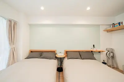 two twin beds in a room with a window at Tokyo Ichiban Kabukicho in Tokyo