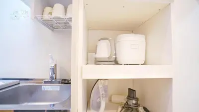 a kitchen with a sink and a cupboard with appliances at Tokyo Ichiban Kabukicho in Tokyo