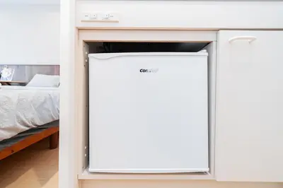 a refrigerator in a bedroom next to a bed at Tokyo Ichiban Kabukicho in Tokyo