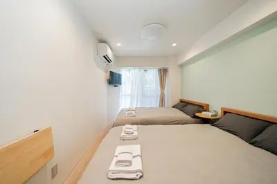 a hotel room with two beds with towels on them at Tokyo Ichiban Kabukicho in Tokyo