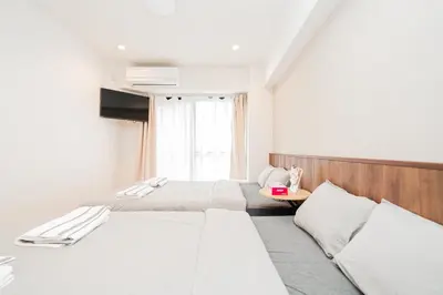 a hotel room with two beds and a television at Tokyo Ichiban Kabukicho in Tokyo