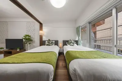 two beds sitting next to each other in a room at NishiShinjuku5chome sta 5 mins walk Max 5 people in Tokyo