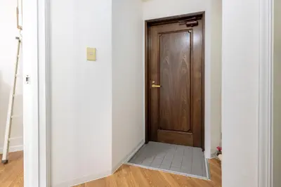 a hallway with a wooden door and a tile floor at \u30e1\u30be\u30f3\u30c9\u30df\u30ca201\u53f7\u5ba4 in Tokyo
