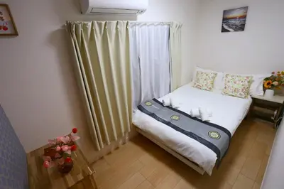 a small bedroom with a bed with a suitcase on it at Mizuken Home Three bedrooms For Family Team in Tokyo