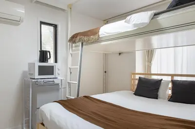 a bedroom with two bunk beds and a microwave at \u30e1\u30be\u30f3\u30c9\u30df\u30ca202\u53f7\u5ba4 in Tokyo
