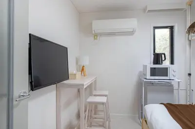 a white room with a tv and a bed at \u30e1\u30be\u30f3\u30c9\u30df\u30ca202\u53f7\u5ba4 in Tokyo