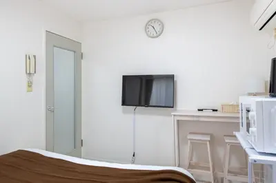 a white room with a bed and a tv on the wall at \u30e1\u30be\u30f3\u30c9\u30df\u30ca202\u53f7\u5ba4 in Tokyo