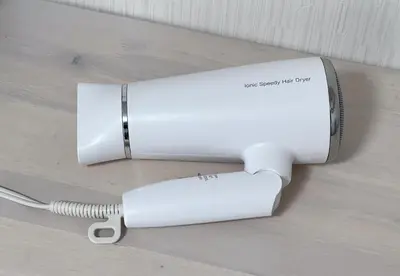a white electric hair dryer sitting on a table at \u30e1\u30be\u30f3\u30c9\u30df\u30ca202\u53f7\u5ba4 in Tokyo
