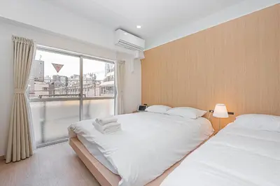 a bedroom with two beds and a large window at ZAITO TOKYO RYOGOKU Hotel in Tokyo