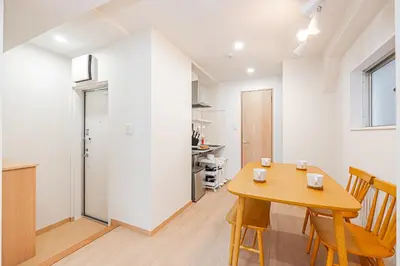a kitchen and dining room with a wooden table and chairs at ZAITO TOKYO RYOGOKU Hotel in Tokyo