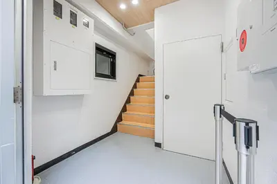 a hallway with a staircase with a door and a stair case at ZAITO TOKYO RYOGOKU Hotel in Tokyo
