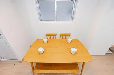 a wooden table with two chairs and two cups on it at ZAITO TOKYO RYOGOKU Hotel in Tokyo