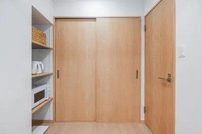 a wooden door in a room with a microwave at ZAITO TOKYO RYOGOKU Hotel in Tokyo