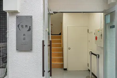 a hallway with stairs and a sign on the wall at ZAITO TOKYO RYOGOKU Hotel in Tokyo