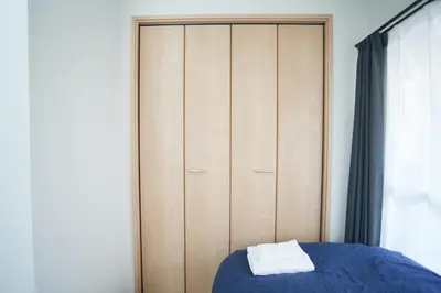 a bedroom with a wooden closet with a blue bed at Asakusa 5 Chome One Bedroom KazeNoItsu 201 in Tokyo