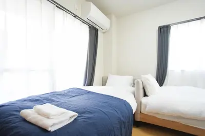 a bedroom with two beds and a window at Asakusa 5 Chome One Bedroom KazeNoItsu 201 in Tokyo