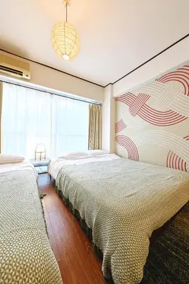 a bedroom with two beds and a large window at \u6075\u6bd4\u5bff\u99c5\u304b\u3089\u5f92\u6b691\u5206 \u6e0b\u8c373\u5206 \u65b0\u5bbf10\u5206 30m2\u3067\u3086\u3063\u305f\u308a \u6700\u9ad8\u306e\u7acb\u5730 302\u53f7\u5ba4 in Tokyo