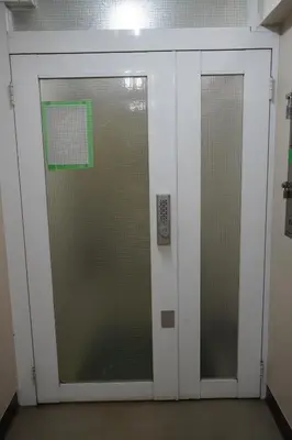two elevator doors in a building with a green sign at \u6075\u6bd4\u5bff\u99c5\u304b\u3089\u5f92\u6b691\u5206 \u6e0b\u8c373\u5206 \u65b0\u5bbf10\u5206 30m2\u3067\u3086\u3063\u305f\u308a \u6700\u9ad8\u306e\u7acb\u5730 302\u53f7\u5ba4 in Tokyo
