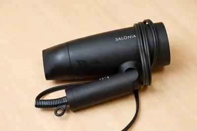 a black hair dryer sitting on a wooden table at \u6075\u6bd4\u5bff\u99c5\u304b\u3089\u5f92\u6b691\u5206 \u6e0b\u8c373\u5206 \u65b0\u5bbf10\u5206 30m2\u3067\u3086\u3063\u305f\u308a \u6700\u9ad8\u306e\u7acb\u5730 302\u53f7\u5ba4 in Tokyo