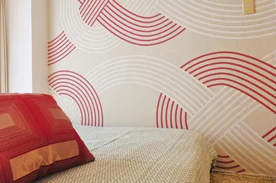 a bedroom with a wall with red and white waves at \u6075\u6bd4\u5bff\u99c5\u304b\u3089\u5f92\u6b691\u5206 \u6e0b\u8c373\u5206 \u65b0\u5bbf10\u5206 30m2\u3067\u3086\u3063\u305f\u308a \u6700\u9ad8\u306e\u7acb\u5730 302\u53f7\u5ba4 in Tokyo