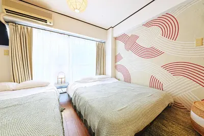 a bedroom with two beds and a window at \u6075\u6bd4\u5bff\u99c5\u304b\u3089\u5f92\u6b691\u5206 \u6e0b\u8c373\u5206 \u65b0\u5bbf10\u5206 30m2\u3067\u3086\u3063\u305f\u308a \u6700\u9ad8\u306e\u7acb\u5730 302\u53f7\u5ba4 in Tokyo