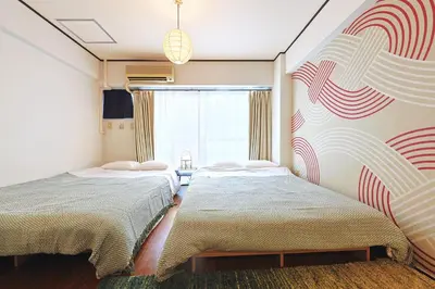 a bedroom with two beds and a window at \u6075\u6bd4\u5bff\u99c5\u304b\u3089\u5f92\u6b691\u5206 \u6e0b\u8c373\u5206 \u65b0\u5bbf10\u5206 30m2\u3067\u3086\u3063\u305f\u308a \u6700\u9ad8\u306e\u7acb\u5730 302\u53f7\u5ba4 in Tokyo